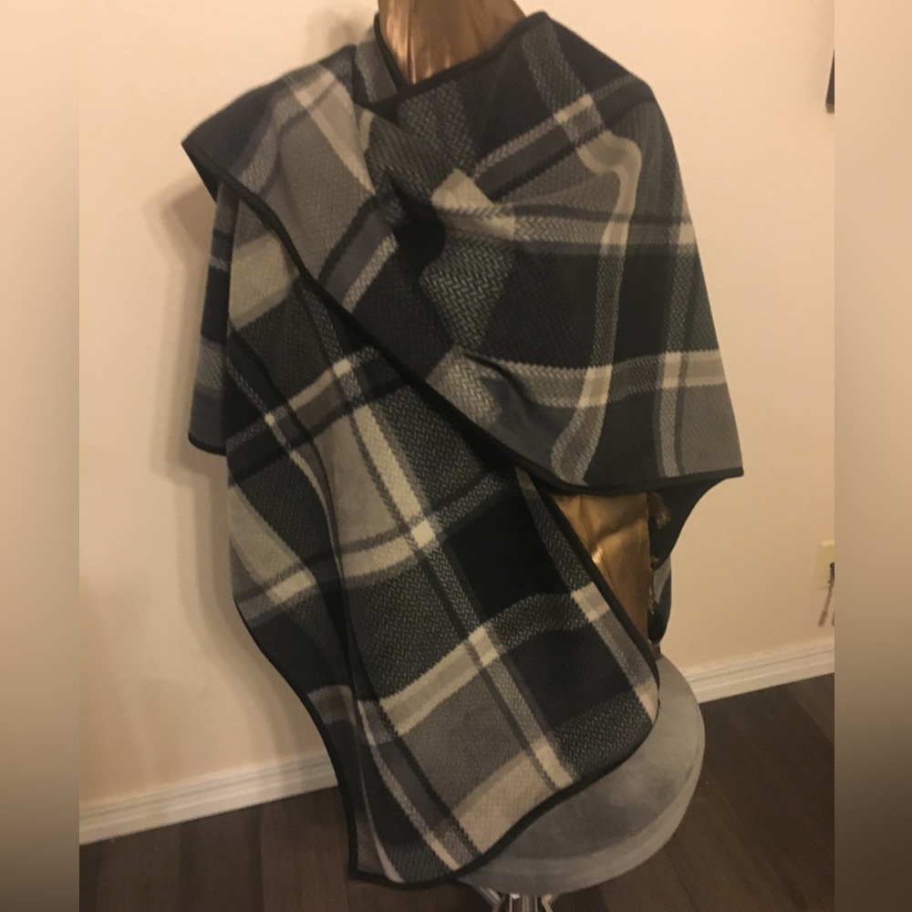 Poncho/ wrap in light dense fleece. Reversible plaid to black, bound in black